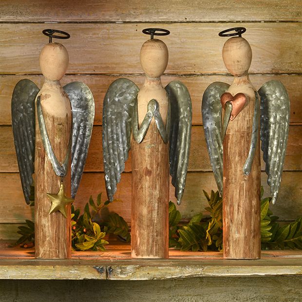 three wooden angel figurines on top of a shelf