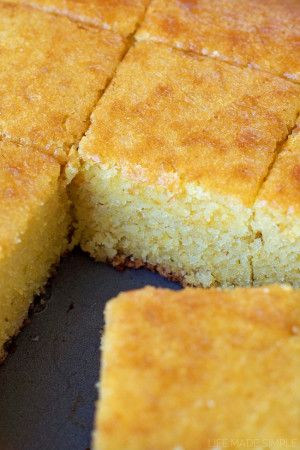 cornbread is cut into squares and placed on a black plate, ready to be eaten