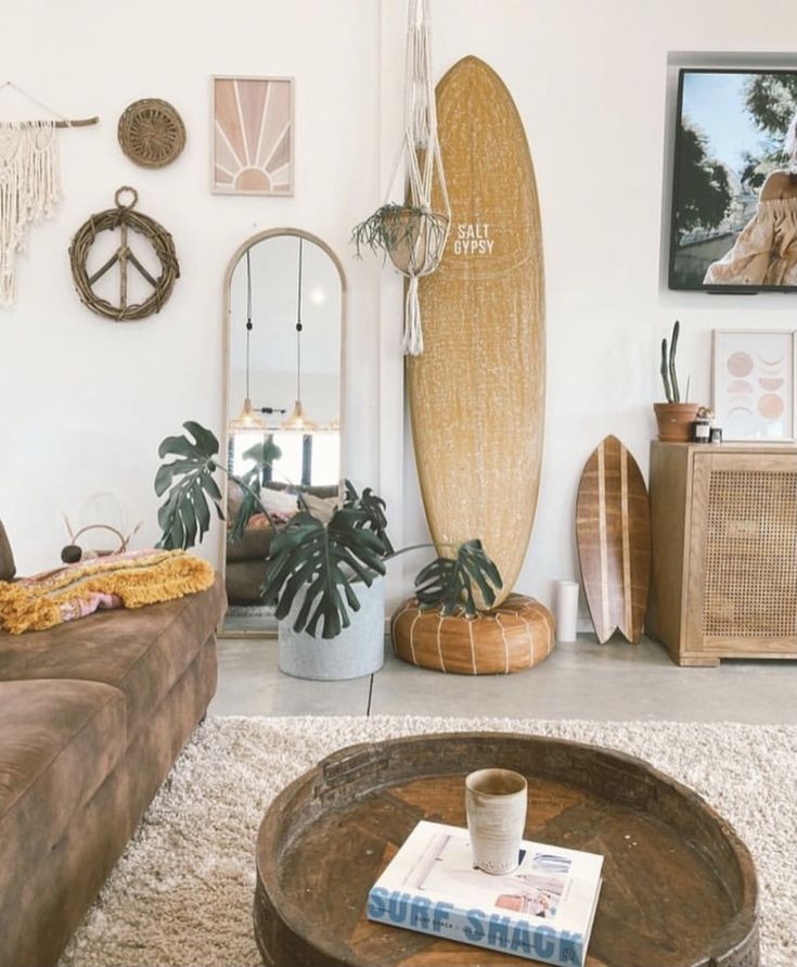 a living room filled with furniture and a surfboard hanging on the wall above it