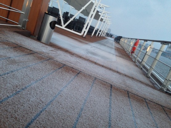 the deck of a cruise ship with no people on it and water in the background