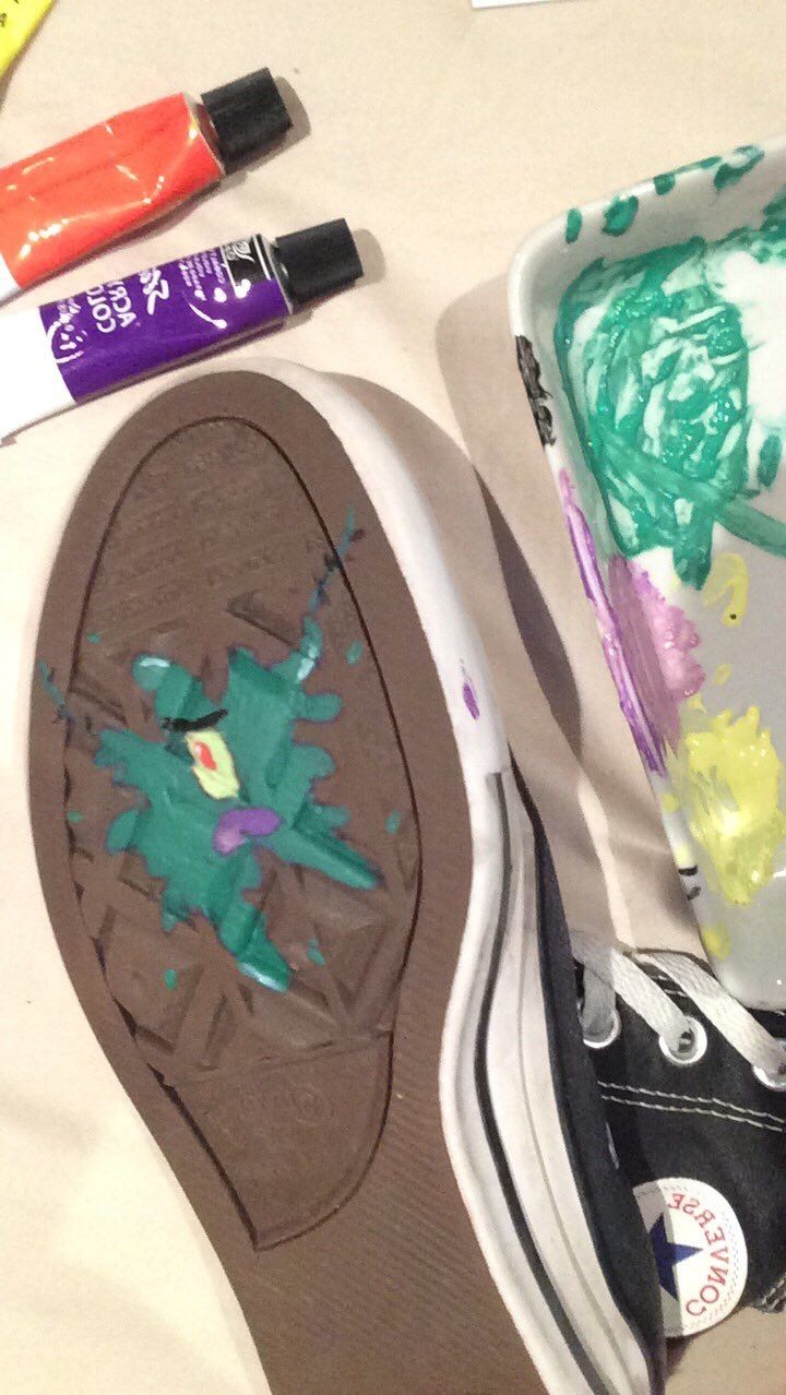 a pair of shoes sitting on top of a table next to crayons and markers