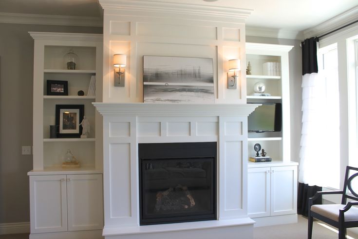 a living room with a fireplace and built in bookshelves