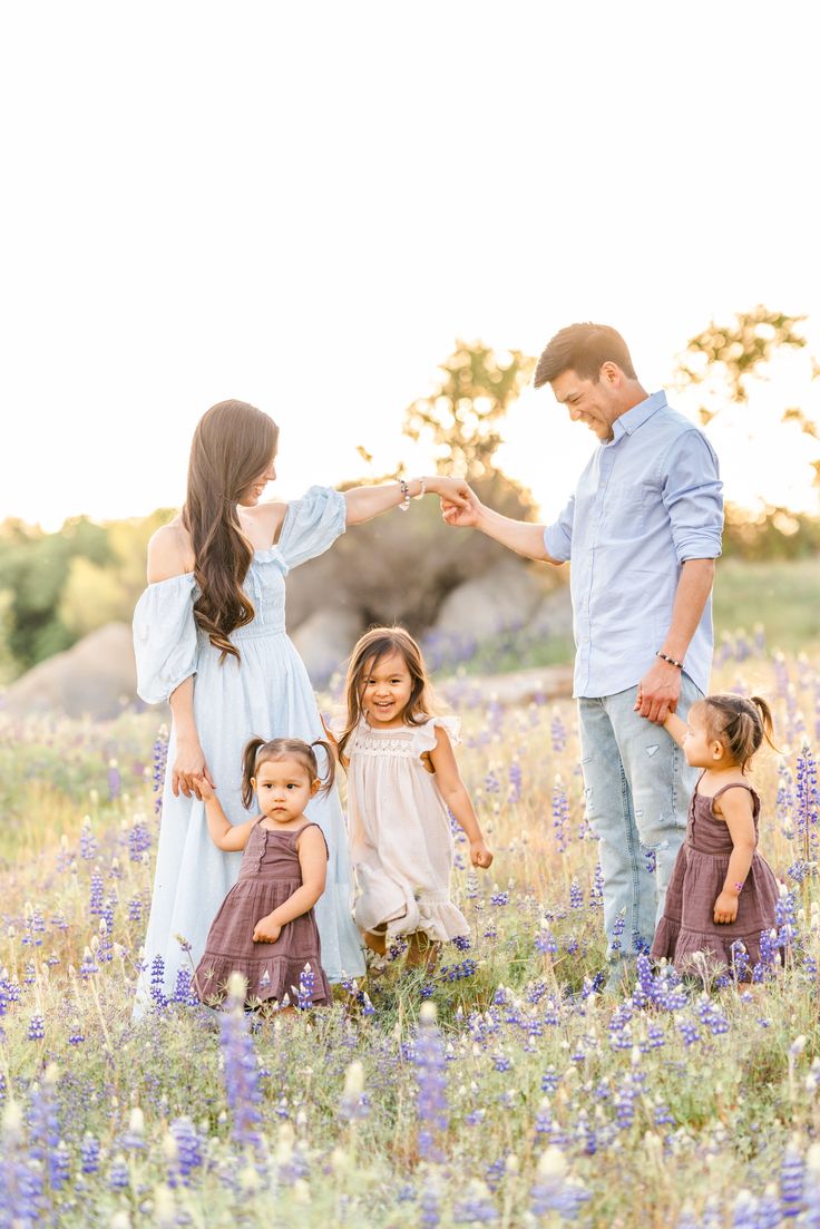 a family holding hands in a field of flowers