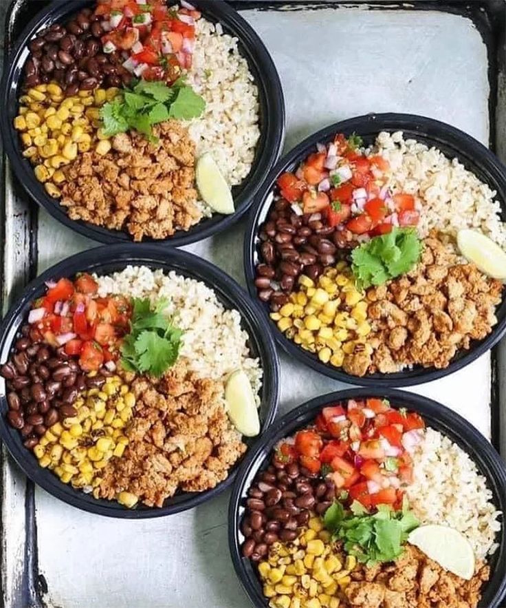 four black plates filled with rice and beans