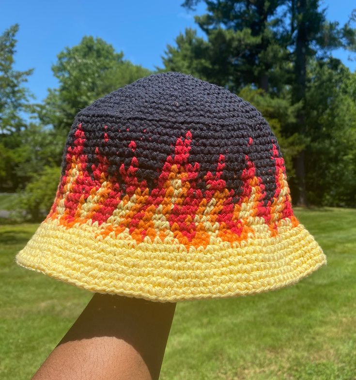 a person wearing a crocheted hat with trees in the background and grass on both sides