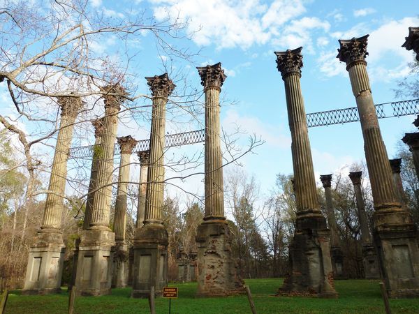 four large stone pillars in the middle of a park