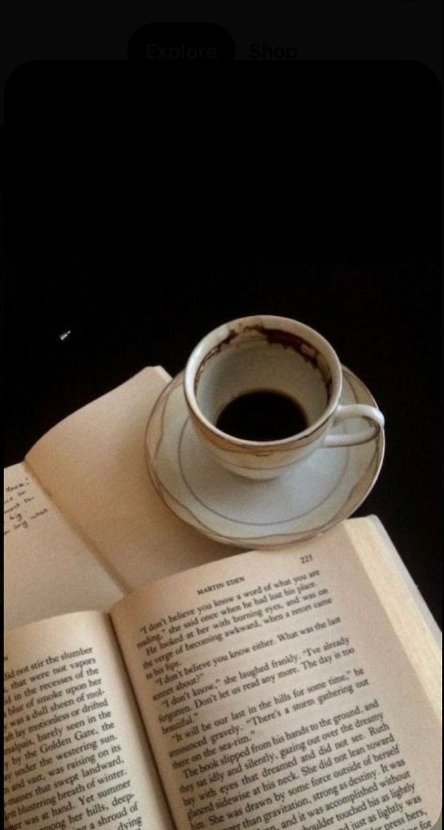 an open book with a cup of coffee on top