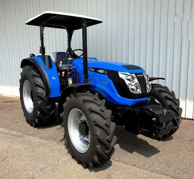 a blue tractor parked in front of a building