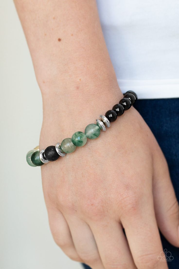 An earthy assortment of shiny black beads, glassy green stone beads, glistening silver accents, and a single black lava rock bead are threaded along a stretchy band around the wrist for a refreshing look.

Sold as one individual bracelet. Bracelets Trendy, Peace Bracelet, Lava Bead Bracelet, Lava Rock, Paparazzi Accessories, World Peace, Paparazzi Jewelry, Silver Accents, Green Stone