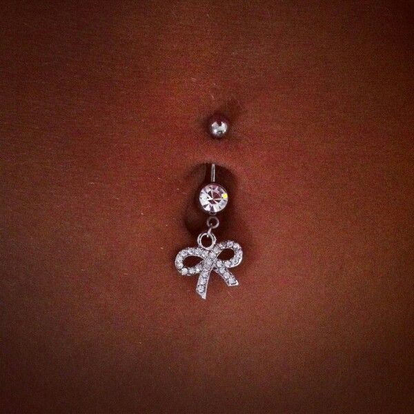 a belly piercing with a bow on it