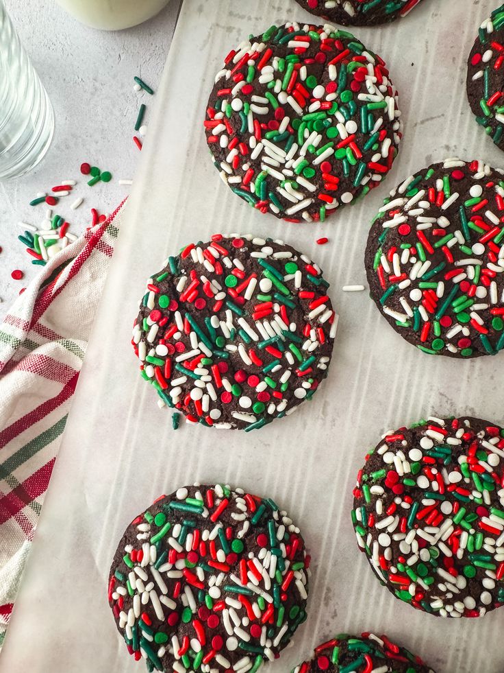 several decorated cookies sitting on top of a baking sheet covered in sprinkles