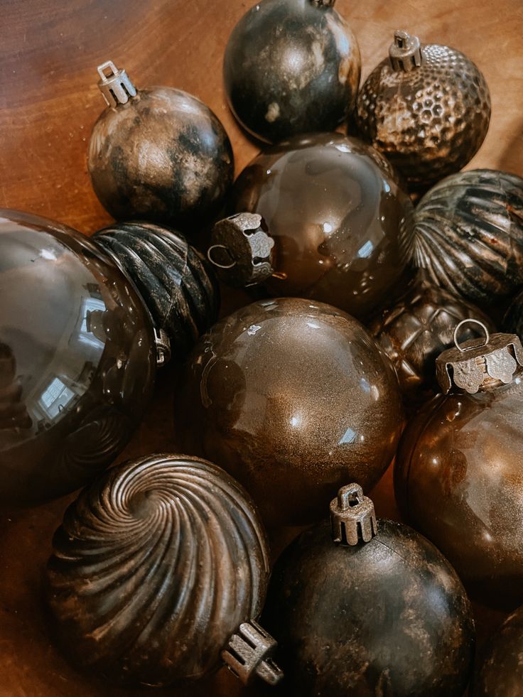 a bunch of ornaments are sitting on a wooden table with one ornament in the middle