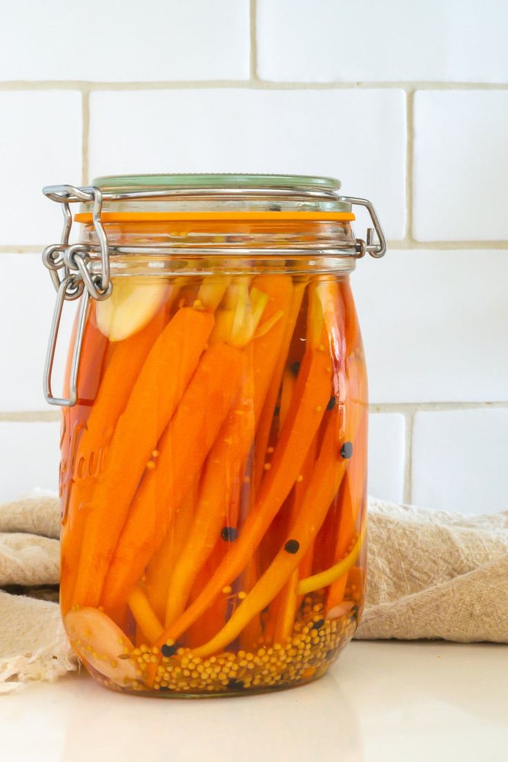 a jar filled with sliced carrots sitting on top of a counter