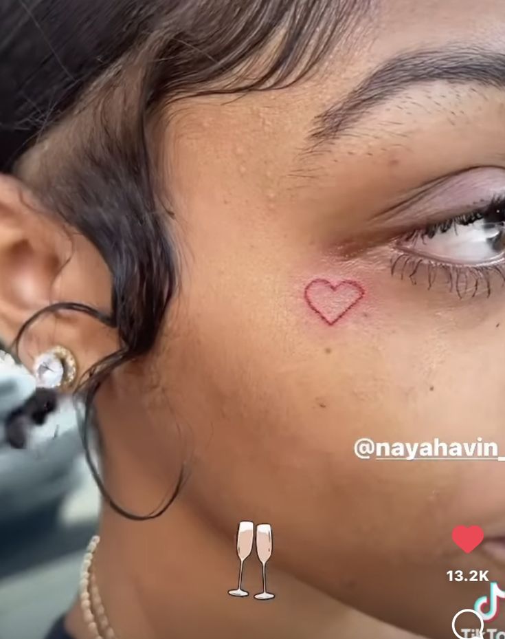 a close up of a person's face with a small heart on her forehead