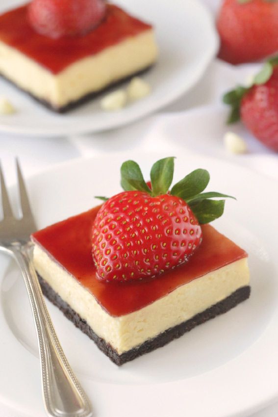 there is a piece of cheesecake with strawberry topping on it and a fork next to it