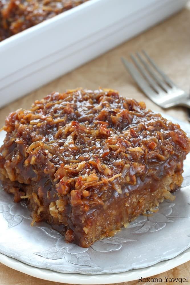 a piece of pecan pie on a plate next to a fork and glass container