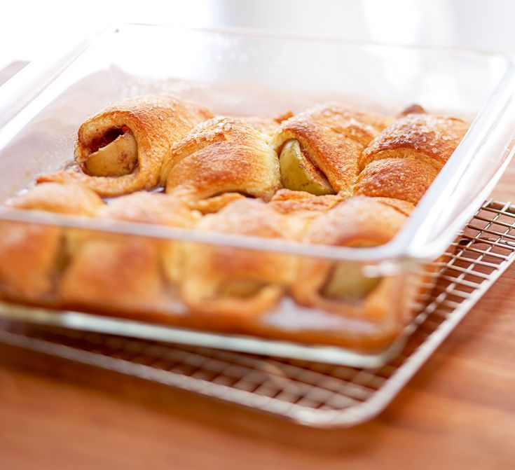 a glass dish filled with pastry on top of a wooden table