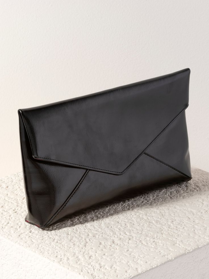 Shine bright and make a bold statement with Shiraleah’s Maddie Envelope Clutch. This chic and stylish oversized clutch is made from trendy metallic PU and adds a pop of glamorous black shimmer to any outfit. Shaped like an envelope with an elegant, triangular folding closure, this large handbag is perfect for fitting your phone, wallet, and other day or nighttime essentials. Pair with the matching Maddie Card Case, or other items from Shiraleah to complete your look! Shiraleah is a trend-driven Trendy Formal Clutch With Magnetic Closure, Chic Envelope Clutch For Evening, Chic Envelope Clutch For Party, Trendy Black Envelope Clutch, Chic Evening Envelope Clutch, Chic Evening Clutch With Magnetic Closure, Chic Envelope Clutch For Events, Chic Envelope Evening Bag For Everyday Use, Versatile Evening Clutch With Magnetic Closure