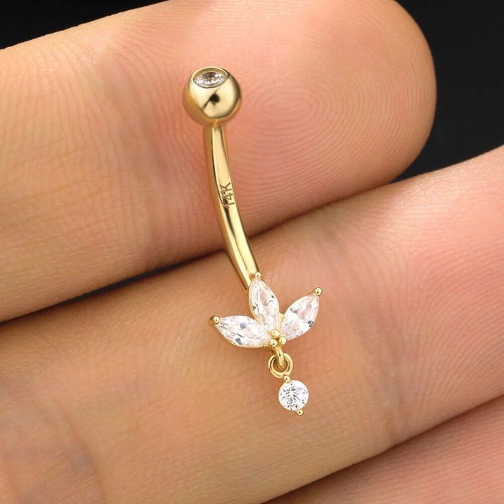 a gold nose ring with crystal stones on the bottom and a butterfly dangling from it's side