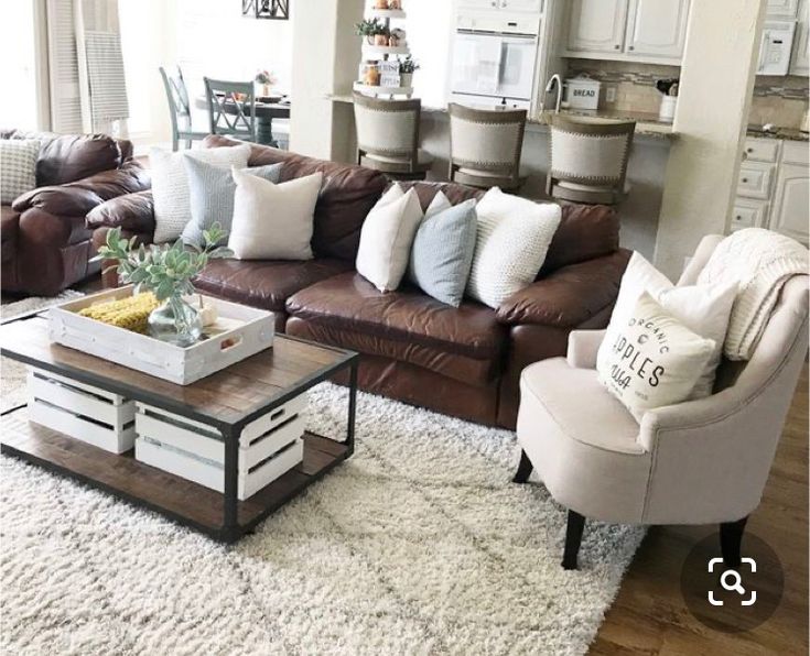 a living room filled with lots of furniture and pillows on top of a white rug