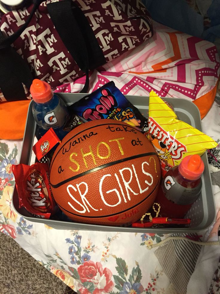 a basket filled with sports items on top of a bed