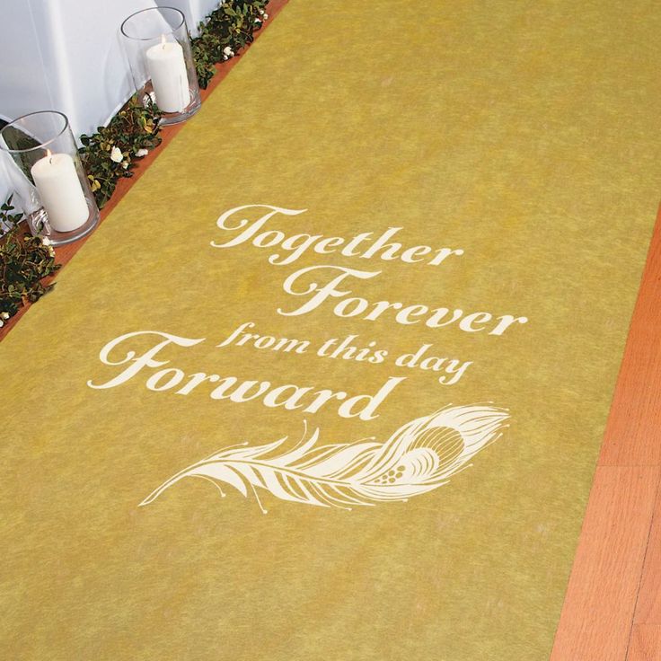 a yellow mat with white writing on it sitting next to candles and some flowers in vases