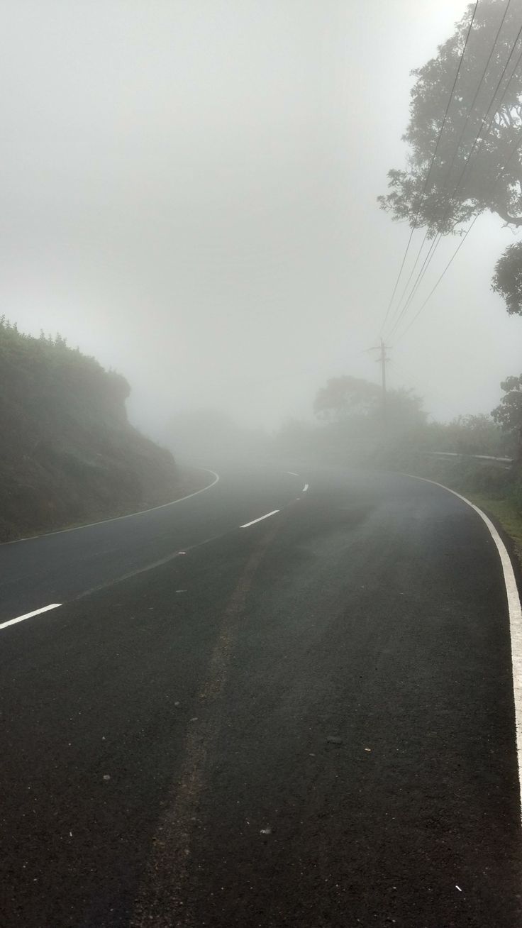 an empty road in the fog on a cloudy day