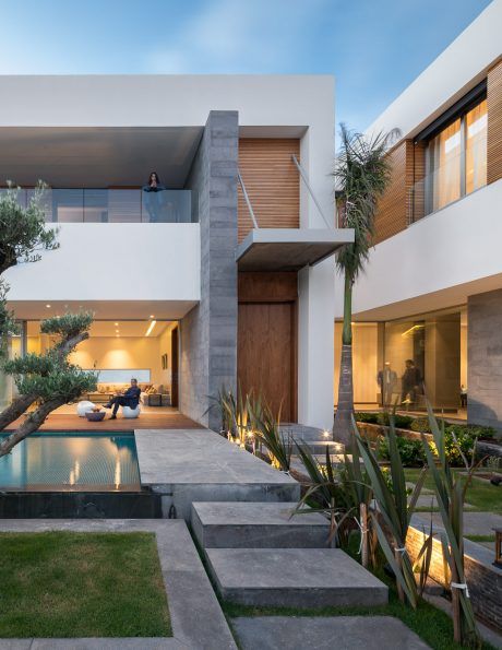 a modern house with an outdoor pool in the front yard and stairs leading up to it