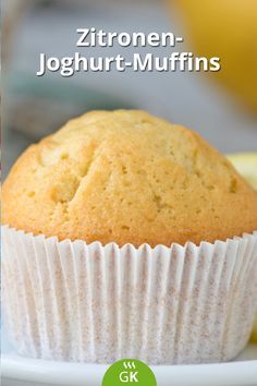 a close up of a muffin on a plate with lemons in the background