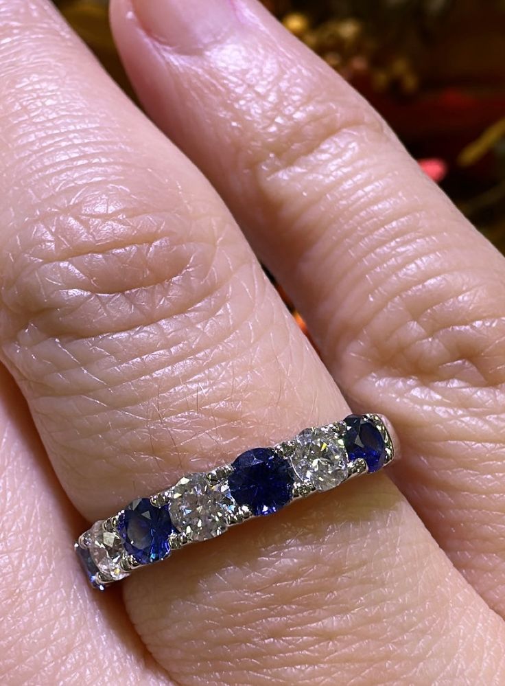 a woman's hand with a diamond and sapphire ring