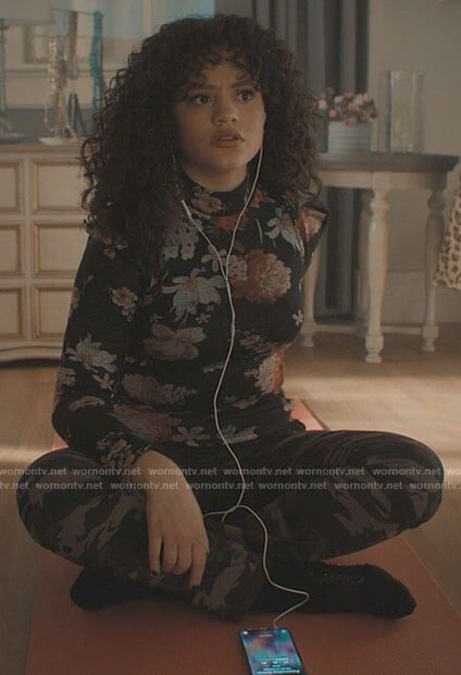 a woman sitting on the floor with headphones in her ears and listening to music