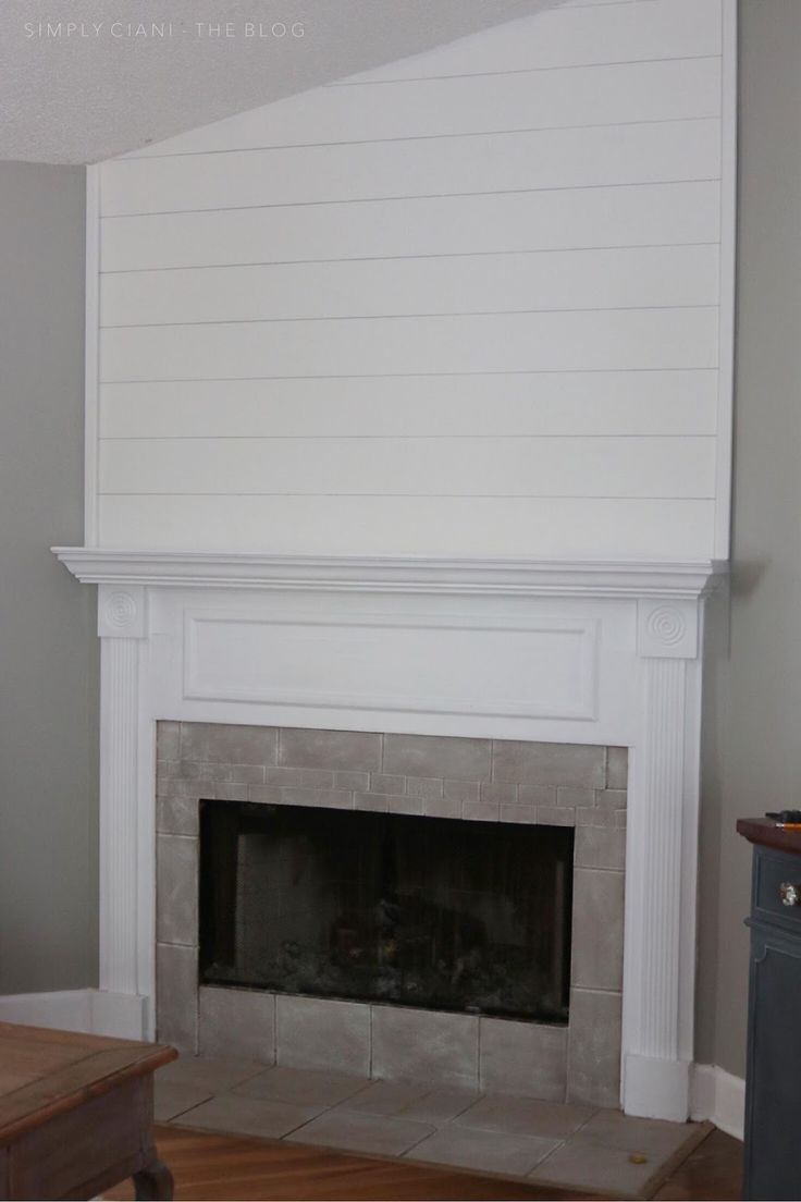 a living room with a fire place and white paint on the fireplace mantels