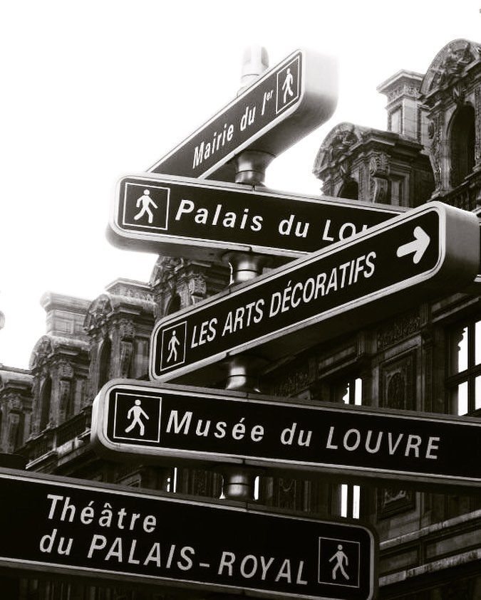 black and white photograph of street signs in paris