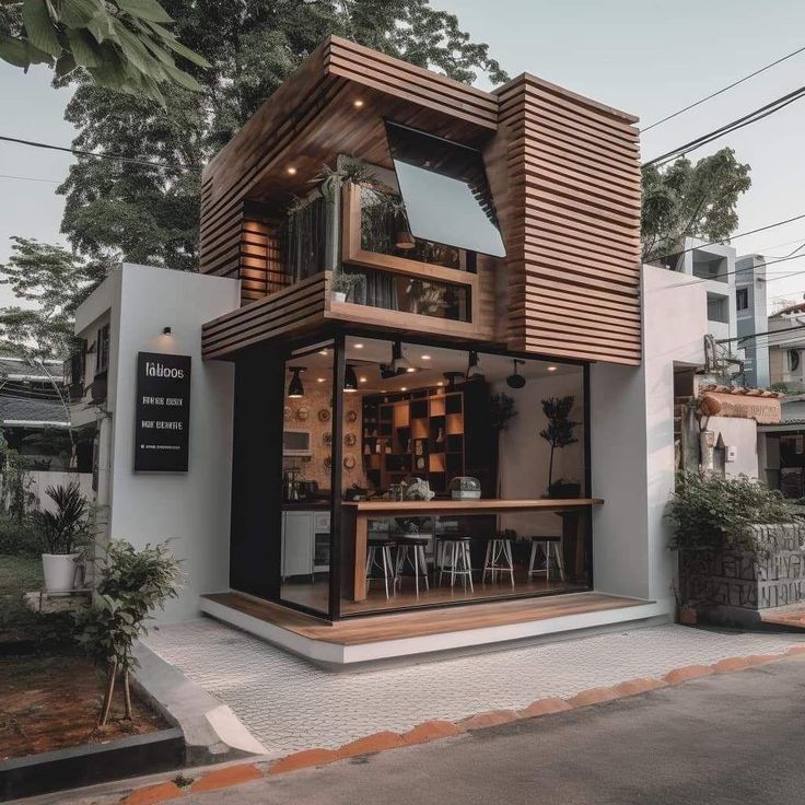 a small white building with wooden slats on the front and sides, along with tables and chairs