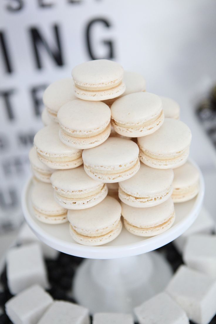 a white plate topped with macaroons on top of a black and white table