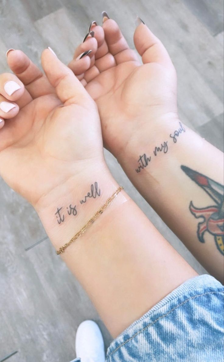 two people with matching tattoos on their arms holding hands and saying it is all we need