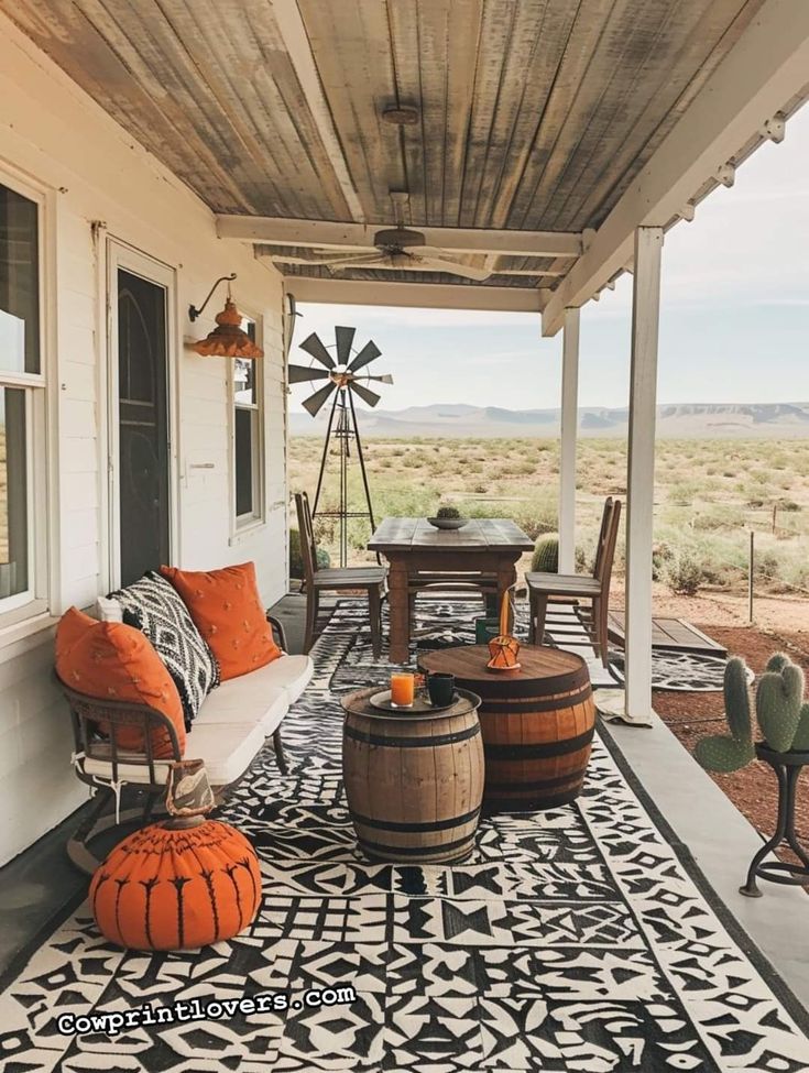 a porch with an orange and black rug on it