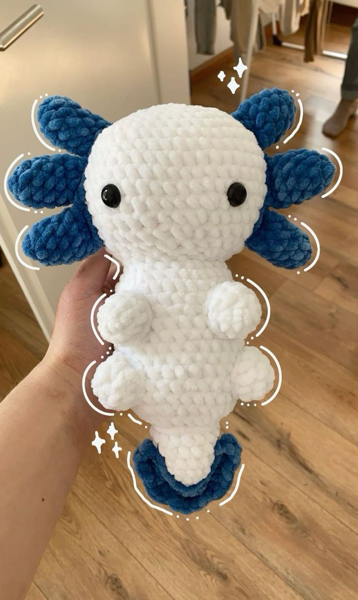 someone is holding up a stuffed animal made out of crocheted yarn and thread