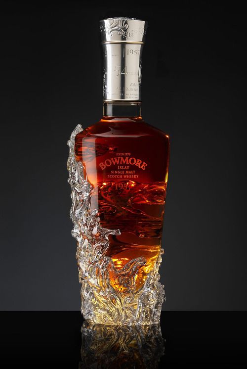 an empty bottle of liquor sitting on top of a glass table with ice around it