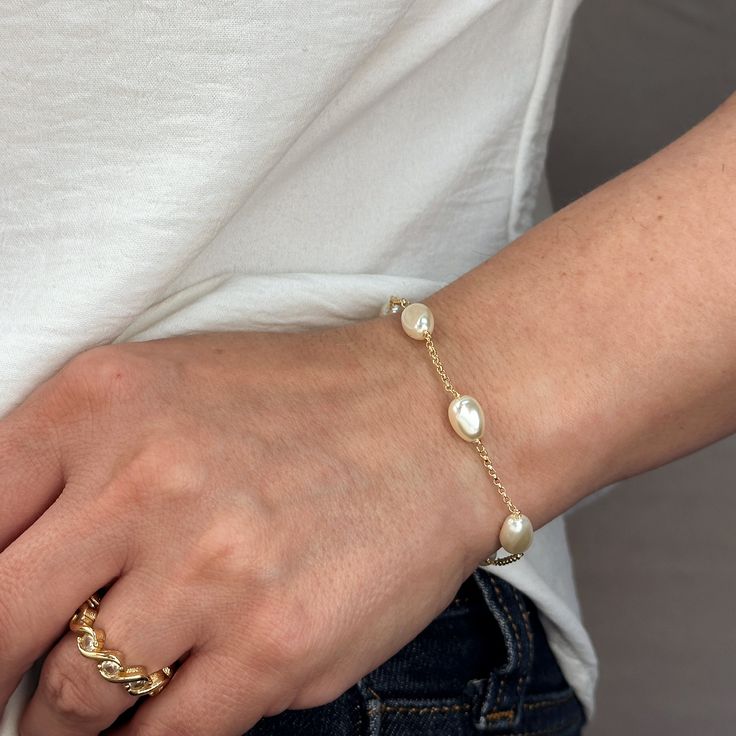 Indulge in the timeless beauty and sophistication of our 18k Gold Filled Spaced Baroque Pearl Bracelet. The perfect blend of elegance and delicacy, this classic piece exudes a luxurious charm that will elevate any outfit. Add a touch of opulence to your wardrobe and captivate with every turn of your wrist. Metal: 18k Gold Filled Width: 10mm Simulated Baroque Pearl Beads Size: 6.5 + 1 inch adjustment. Hypoallergenic Water-resistant Handcrafted in Brazil Elegant Pearl Chain Bracelet For Formal Occasions, Elegant Wedding Pearl Chain Bracelet, Elegant Adjustable Chain Bracelet With Pearl Charm, Elegant Adjustable Pearl Charm Chain Bracelet, Classic Rose Gold Jewelry For Everyday Elegance, Elegant Pearl Charm Bangle Jewelry, Elegant White Chain Bracelet With Pearl Charm, Elegant Formal Chain Bracelet With Oyster Design, Classic Gold Plated Jewelry With Elegant Design