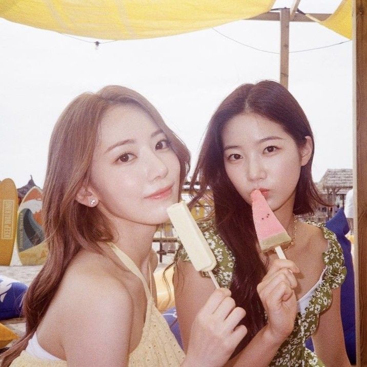 two young women eating ice cream at an outdoor event