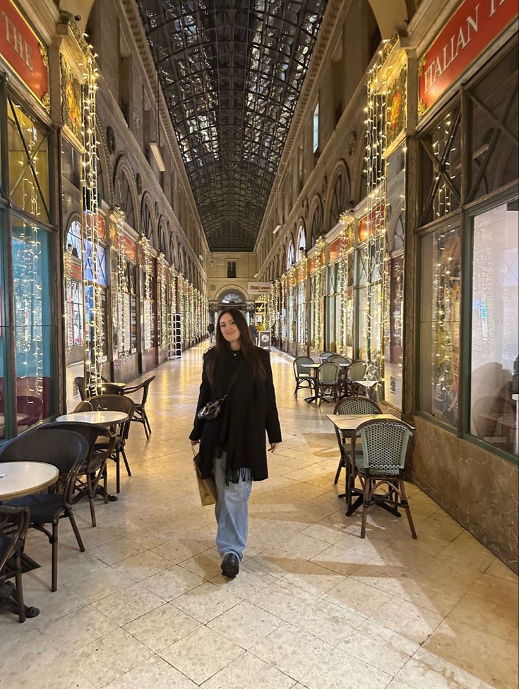 a woman is walking down an empty shopping mall