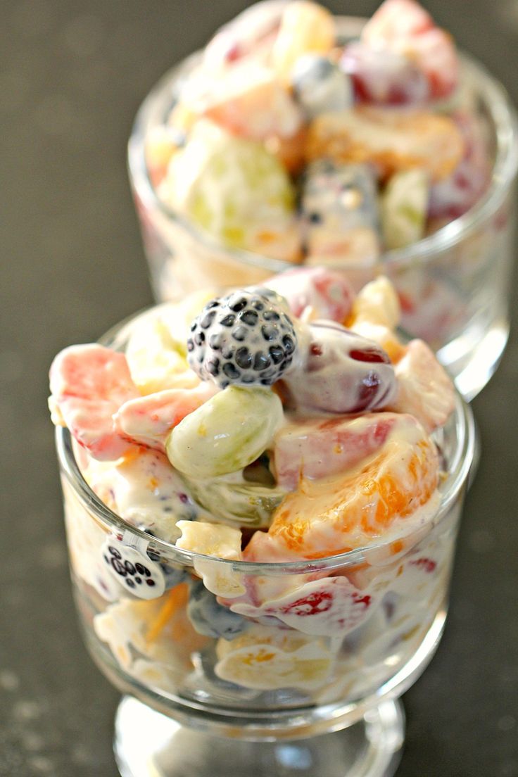 two glass bowls filled with fruit salad on top of a table