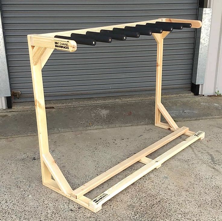 a wooden frame sitting on the ground in front of a garage door with an ironing board attached to it