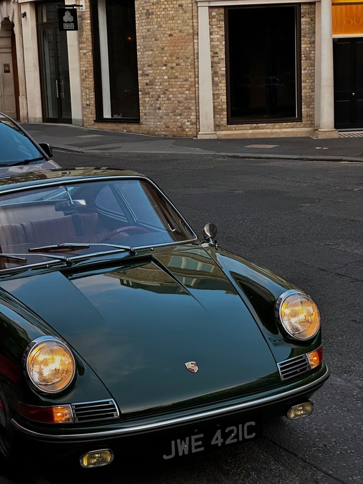 a green porsche parked on the side of the road