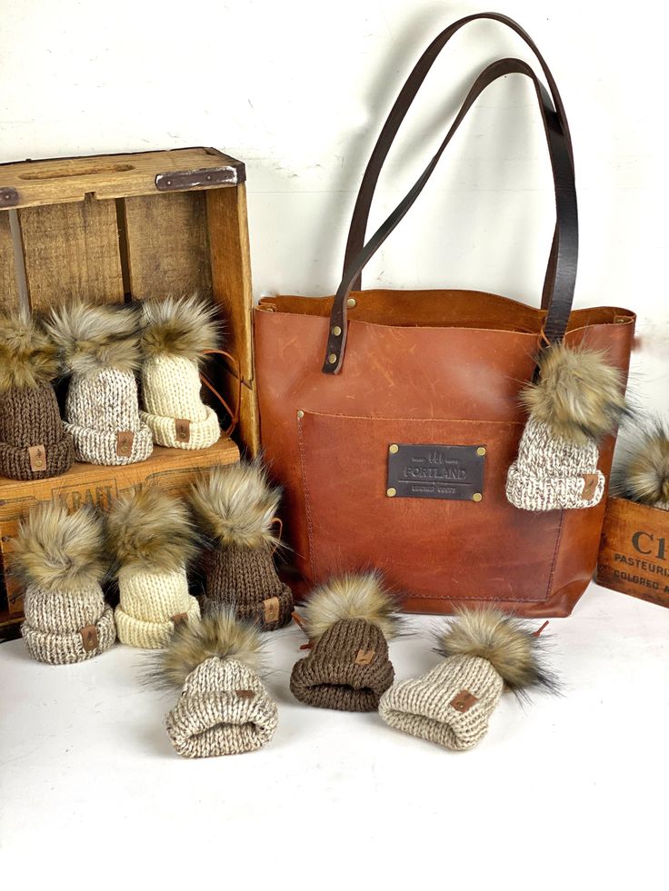 several knitted hats and purses sitting next to each other