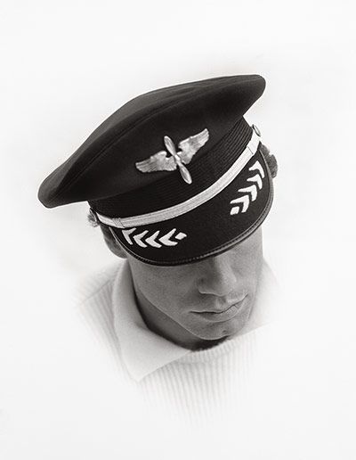 a black and white photo of a mannequin's head wearing a hat