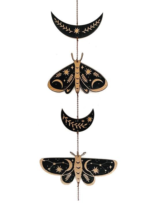 three black and gold moths hanging from strings with stars on them, one is in the shape of a crescent