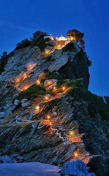 a large rock with some lights on it's face and stairs going up to the top