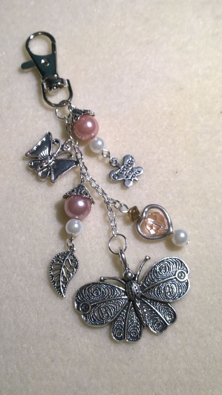 a keychain with charms attached to it on a white surface, including a dragonfly